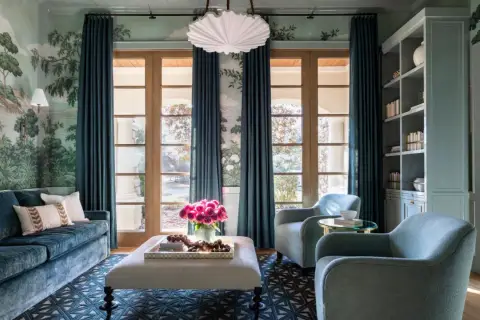 Elegant teal curtains frame French doors, showcasing a lush garden mural and reflecting current curtain trends.