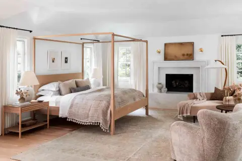 A cozy bedroom with a four-poster bed, fireplace, and plush seating, perfect for romance in bed.