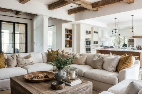 A cozy living room showcasing types of rustic interior design, featuring exposed wooden beams, a distressed coffee table, and textured neutral furnishings.